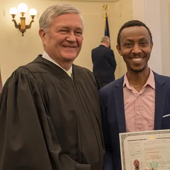 Senior Judge D. Brock Hornby shakes hands with a newly naturalized citizen. 