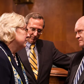 Sen. Chris Coons, right, confers with Judge Julia S. Gibbons and Judge John D. Bates, Director of the Administrative Office of the U.S. Courts.