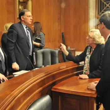 Judge Julia S. Gibbons, Budget Committee chair, speaks with Sen. Chris Coons (D-Del.), left, and Sen. John Boozman (R-Ark.). They are, respectively, ranking minority member and chair of the Senate Appropriations Subcommittee on Financial Services and Gene