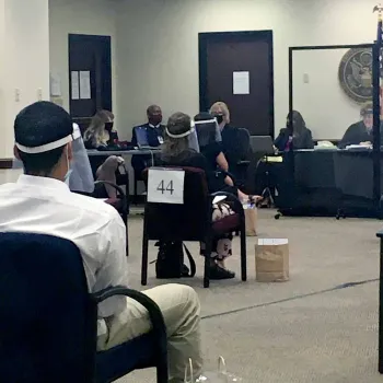 Socially distanced prospective jurors wait their turn during the jury selection process. Judge Lynn and the attorneys are seated at the front of the room behind plexiglass.