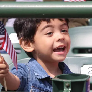 A child waives a flag from the stands at Wrigley Field in celebration. Photo credit: Jim Slonoff