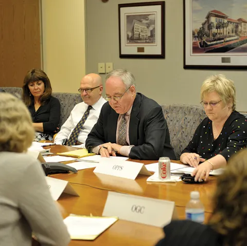 Image of men and women in conference room