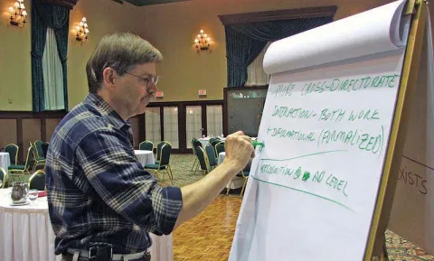 Image of a man writing on a drawing board